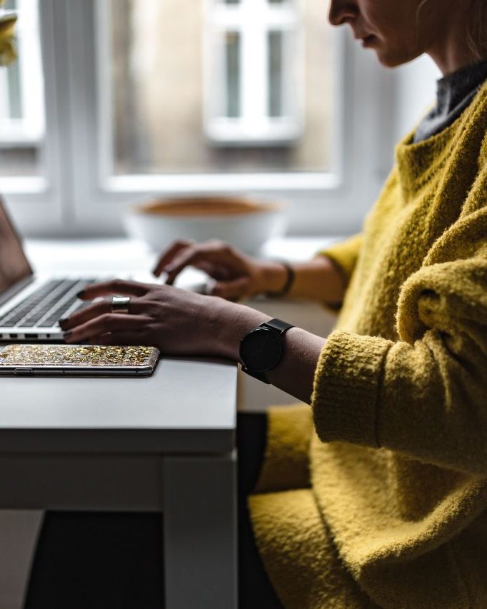 Retailer working on a laptop at her counter